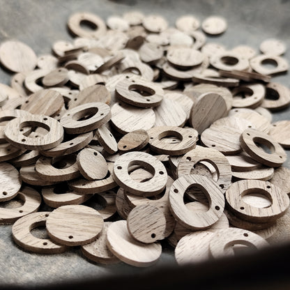 Geschliffene, ungeölte Formen aus Nussholz in der Werkstatt, als Rohmaterial für handgefertigte Holzschmuckteile